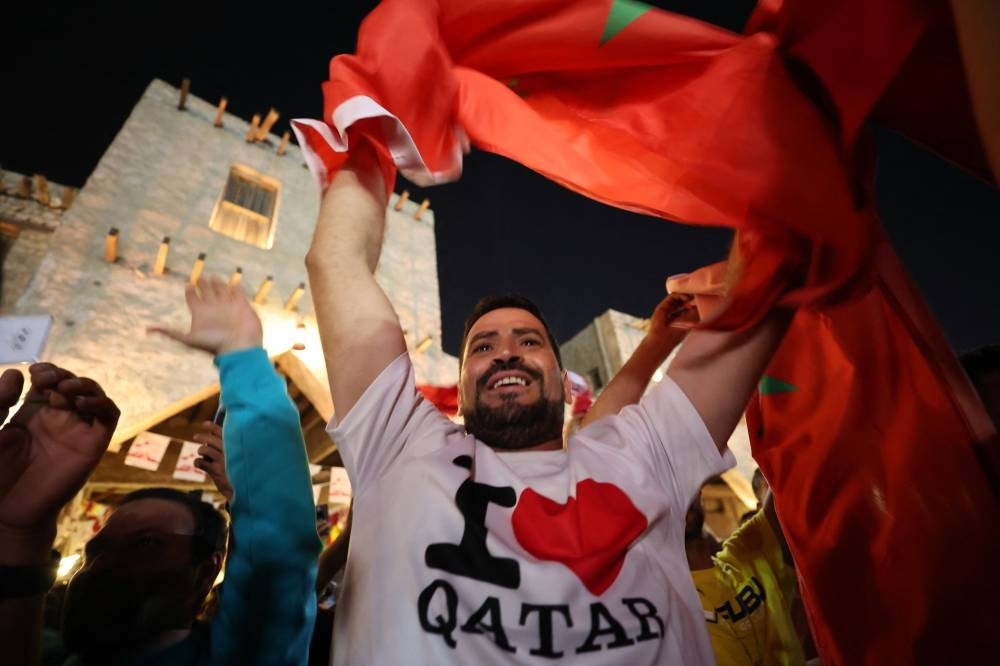 Moroccan fans celebrate in Souq Waqif after their team qualified for the knockout stages by beating Canada yesterday. 