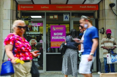 People walk past a 'Now Hiring' sign in New York City. US employers added more jobs than forecast and wages surged by the most in nearly a year, pointing to enduring inflation pressures that boost chances of higher interest rates from the Federal Reserve.
