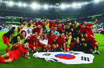 South Korea players celebrate at the Education City Stadium after qualifying for the knockout stages yesterday. (Reuters)