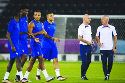 France's coach Didier Deschamps (right) and France's assistant coach Guy Stephan (second right) speak together as (from left) France's forward Ousmane Dembele,  midfielder Aurelien Tchouameni, defender Jules Kounde and forward Kylian Mbappe walk past them during a training session at the Al Sadd SC training centre in Doha, yesterday.