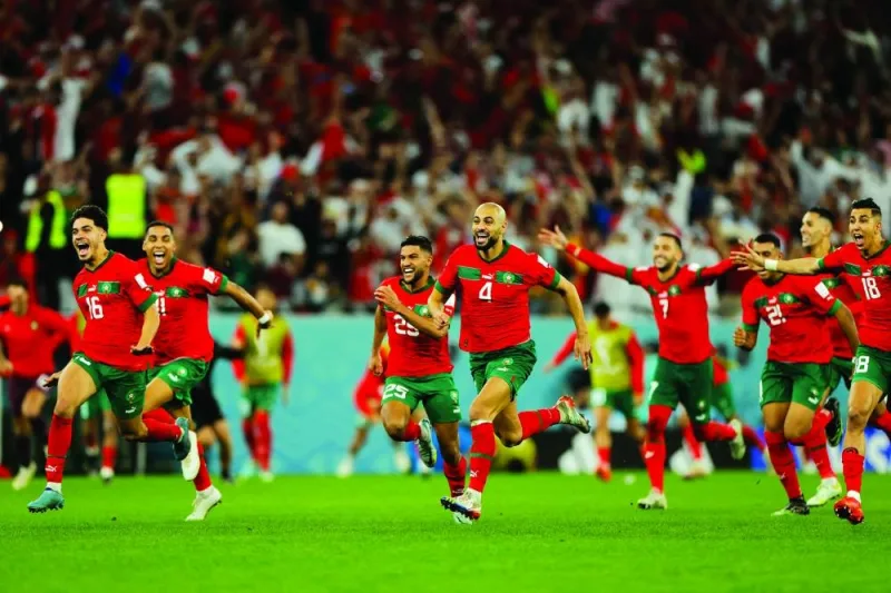 Morocco players celebrate after they won on penalty shoot-out the Qatar 2022 World Cup round of 16 football match against Spain yesterday (AFP).