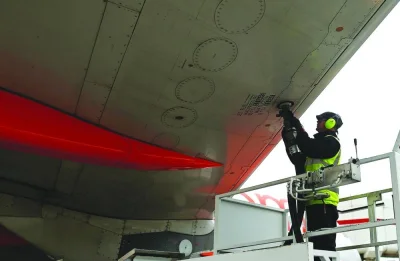 A member of the ground crew connects a fuel hose to the wing of an Airbus Group aircraft, operated by EasyJet, during the refuelling process between flights at the north terminal of London Gatwick airport.