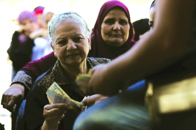 People line up at a temporary tent with government subsidised goods in Cairo (file). A weaker currency is driving up prices for the nation of about 104mn people, with inflation data due this week expected to show the further impact of the pound’s plunge.