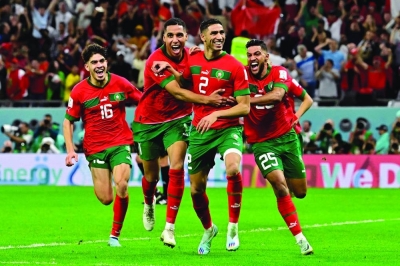 Morocco’s defender Achraf Hakimi (centre) celebrates with teammates after converting the last penalty during the penalty shoot-out to win the Qatar 2022 World Cup Round of 16 match against Spain at the Education City Stadium in Al Rayyan on Tuesday. (AFP)