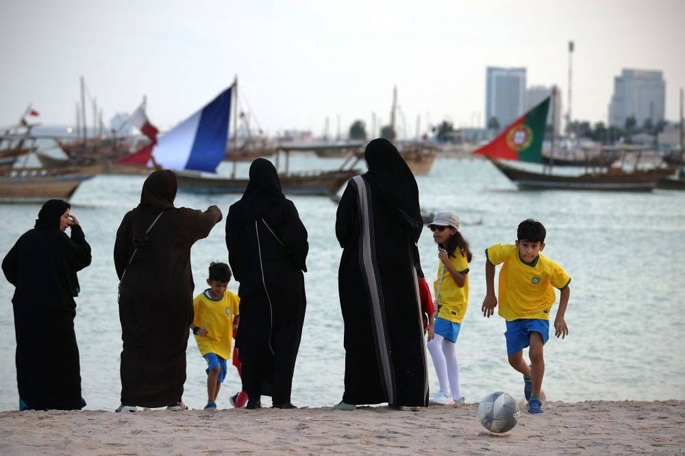 A boy chases a football alongside his family on the Katara Beach in Doha yesterday. Qatar’s hosting of the FIFA World Cup and the AFC Asian Cup in 2023 will build the momentum towards travel and tourism recovery in the GCC region, the EIU has said in a report.