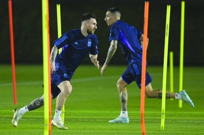 Argentina’s forward Lionel Messi (left) and Angel di Maria take part in a training session at Qatar University in Doha yesterday, on the eve of the Qatar 2022 World Cup quarter-final against Netherlands. (AFP)