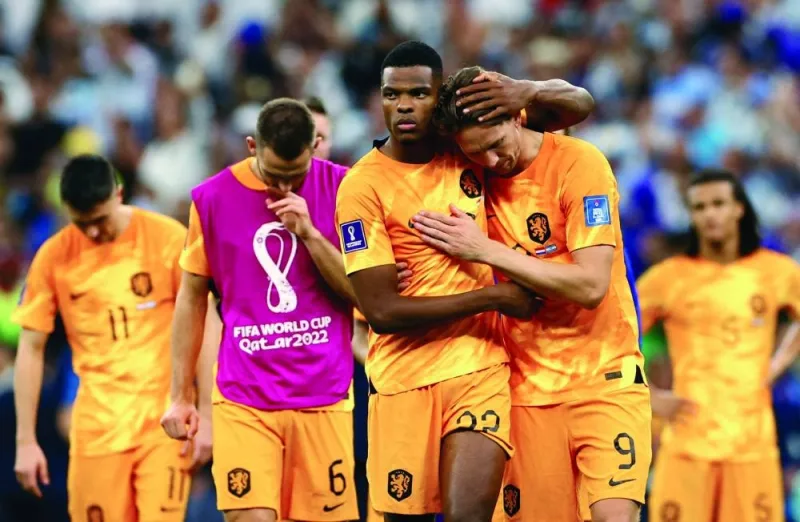 Netherlands' Denzel Dumfries and Luuk de Jong look dejected after being eliminated from the World Cup. (Reuters)
