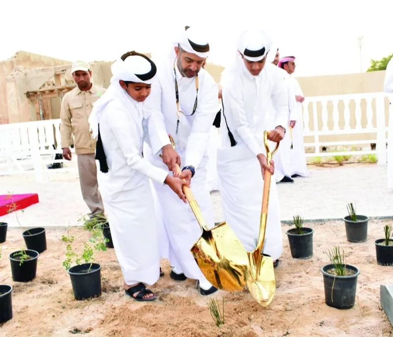 Nasser al-Khater planting a tree with his sons.
