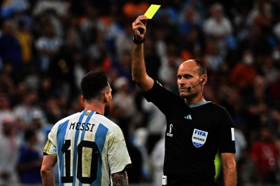 Spanish referee Antonio Mateu Lahoz shows a yellow card to Argentina&#039;s forward #10 Lionel Messi during the Qatar 2022 World Cup quarter-final football match between Netherlands and Argentina at Lusail Stadium on December 9. AFP