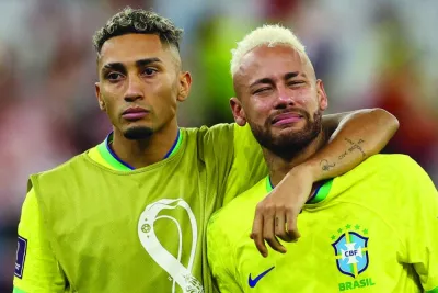 Brazil’s forward Neymar (right) is consoled by teammate Raphinha after their team lost the Qatar 2022 World Cup quarter-final football match against Croatia at Education City Stadium in Al Rayyan, on Friday. (AFP)
