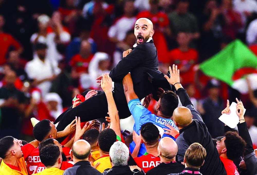 Morocco’s players carry their coach Walid Regragui as they celebrate after winning the Qatar 2022 World Cup quarter-final against Portugal at the Al Thumama Stadium in Doha yesterday. (AFP)