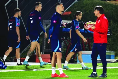 Croatia's coach Zlatko Dalic (right) speaks with his team's defender Dejan Lovren (C) as their teammates take part in a training session at Al Erssal Training Site 3 in Doha yestyerday, ahead of their third place play-off match against Morocco Saturday. (AFP)