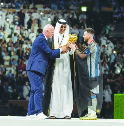His Highness the Amir Sheikh Tamim bin Hamad al-Thani and FIFA President Gianni Infantino handing over the winner&#039;s trophy to Argentina captain Lionel Messi at Lusail Stadium. 