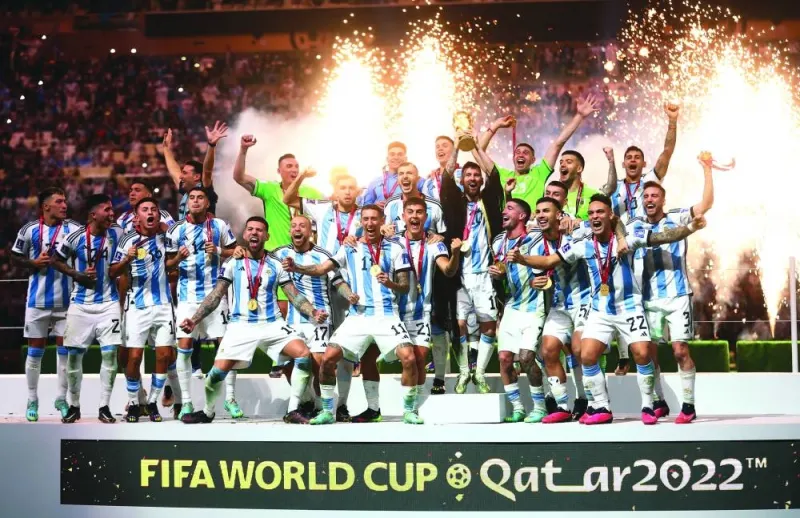 Argentina’s Lionel Messi celebrates with the trophy and teammates after winning the FIFA World Cup Qatar 2022 following their penalty shootout win over France in the final played at Lusail Stadium yesterday. (Reuters)