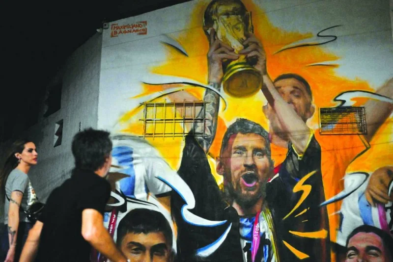 A mural by artist Maxi Bagnasco, depicting Argentina’s captain and forward Lionel Messi raising the FIFA World Cup trophy after winning the tournament in Qatar, is seen in Buenos Aires. (AFP)