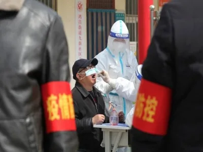 A medical worker in a protective suit collects a swab sample from a resident for nucleic acid testing during a mass testing for the coronavirus disease (COVID-19), at a residential compound in Jiaozuo, Henan province, China March 23, 2022. China Daily via REUTERS   ATTENTION EDITORS - THIS IMAGE WAS PROVIDED BY A THIRD PARTY. CHINA OUT.