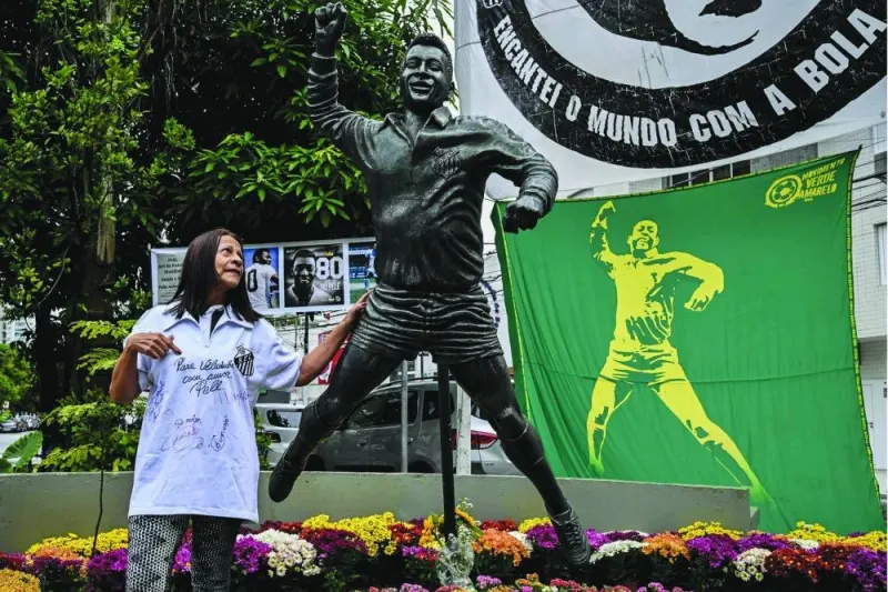 A woman poses for a picture next to a statue depicting Brazilian football legend Pele in Santos, Brazil, yesterday. (AFP) 