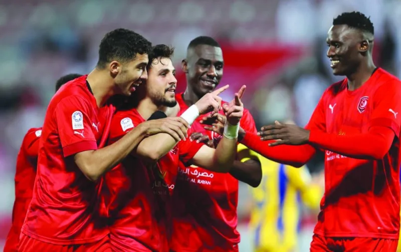 Al Duhail’s Bassam al-Rawi (second left) celebrates with teammates after scoring against Al Gharafa at the Abdullah Bin Khalifa Stadium yesterday.