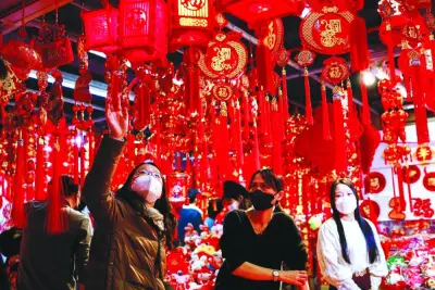 A customer looks at decorations for Chinese Lunar New Year at a market selling Spring Festival ornaments ahead of the Chinese Lunar New Year festivity, in Beijing.