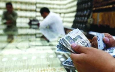 A man counts Saudi riyal banknotes at a jewellery store story in Riyadh. S&P expects the Saudi government to continue issuing sukuk in local currency to develop the local capital market, although recent pressure on banks&#039; liquidity resulted in lower activity than 2021.
