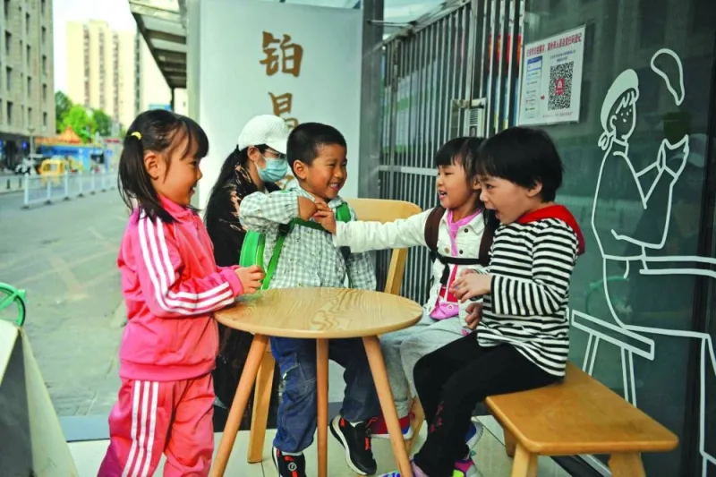 Children play outside a cafe in Beijing. China’s population shrank last year for the first time in more than six decades, official data showed yesterday, as the world’s most populous country faces a looming demographic crisis.
