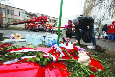 People leave tributes at the site of a helicopter crash in the town of Brovary, outside Kyiv, yesterday. (Reuters)

