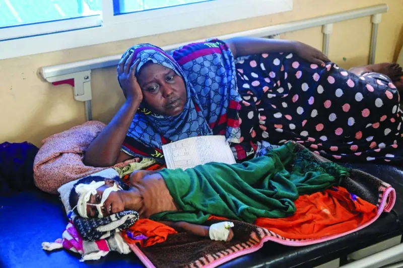 Somali displaced mother Binti Moalim Hassan lays beside her malnourished 3-year-old daughter Faduma in a hospital in Mogadishu last October. (Reuters)