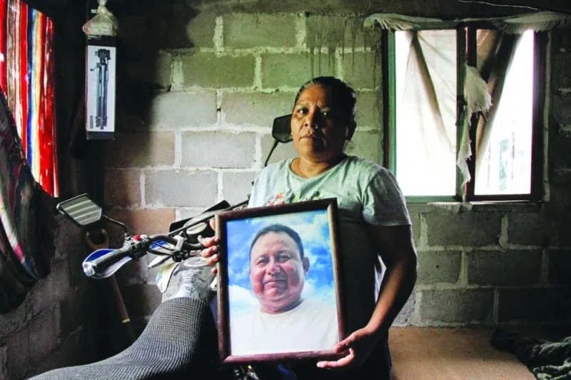 Marilu Sanchez holds a framed picture of her late husband Gustavo Sanchez, a journalist killed by assailants while riding his motorcycle with his son, at her home in Morro de Mazatan, in Oaxaca state, Mexico, on October 18, 2022. (Reuters)
