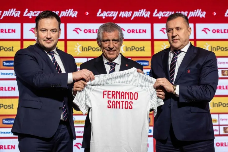 Newly appointed head coach of the Polish national football team Fernando Santos (C), the secretary general of Polish Football Association Lukasz Wachowski (L) and the president of the Polish Football Association Cezary Kulesza (R) pose with a shirt bearing the name of Fernando Santos during his presentation to the press at the national stadium in Warsaw, on January 24, 2023. (AFP)