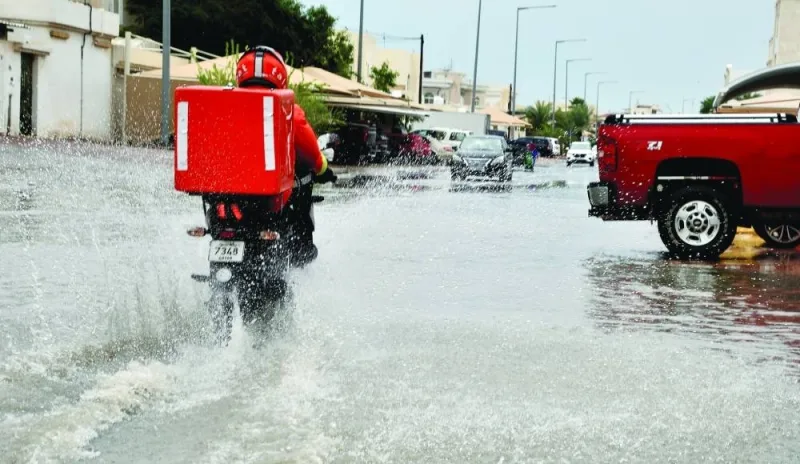 A delivery rider negotiates a flooded street in Doha Friday. PICTURE: Shaji Kayamkulam