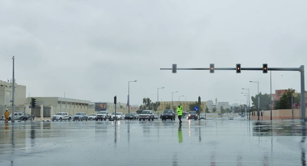 A traffic policeman guiding vehicles at a Doha intersection yesterday when the signals temporarily malfunctioned in the rain. PICTURE: Shaji Kayamkulam