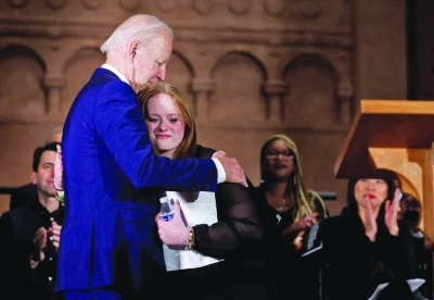 FILE PHOTO: US President Joe Biden embraces Jackie Hegarty, a Sandy Hook school shooting survivor, during the 10th Annual National Vigil for All Victims of Gun Violence in Washington, on December 7, 2022.  