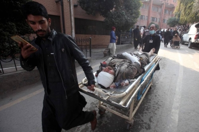 People push a stretcher carrying an injured victim after a mosque blast inside the police headquarters, at a hospital in Peshawar. AFP