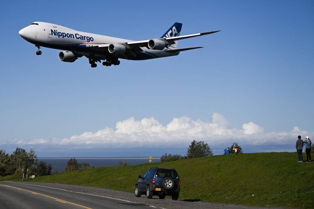 In this file photo taken on September 17, 2022, people watch as a Nippon Cargo Airlines Company Boeing 747 aircraft lands at the Ted Stevens International Airport (ANC) in Anchorage, Alaska. AFP