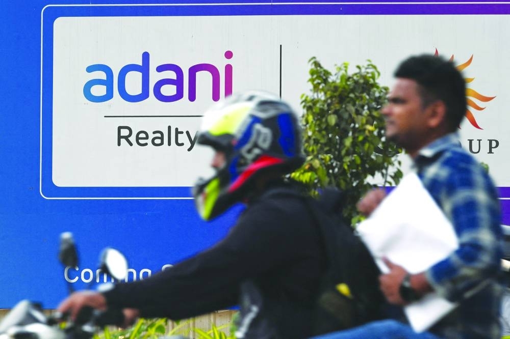 
Motorists ride past the signage of an upcoming residential project by Adani Realty, a company of Indian conglomerate Adani in Mumbai yesterday. Hindenburg has said it held its position, which profits from the fall in the value of Adani Group shares and bonds, “through US-traded bonds and non-Indian-traded derivatives, along with other non-Indian-traded reference securities.”