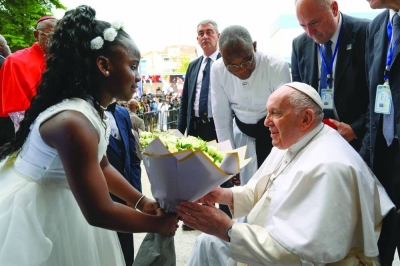 Pope Francis receives flowers from a child during his apostolic journey in Kinshasa yesterday.