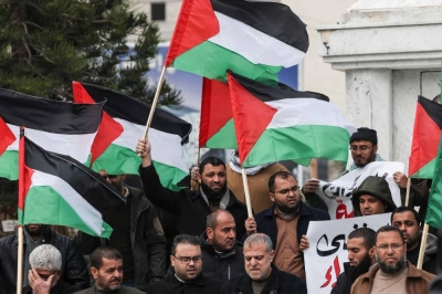 Palestinians wave national flags during a protest in Gaza City after five Palestinian fighters were killed by Israeli forces in a raid yesterday in the occupied West Bank.