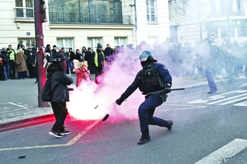 French police push back protesters as clashes erupt during a demonstration in Paris yesterday. (AFP)