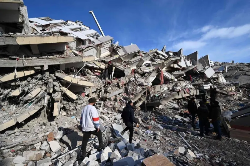 Relatives of victims stand beside the rubble of a collapsed building in the southeastern Turkish city of Kahramanmaras (AFP)