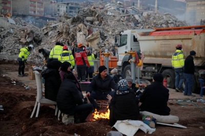People gather near the site of a collapsed building as rescuers search for survivors, in the aftermath of an earthquake, in Kahramanmaras, Turkey, Thursday. REUTERS