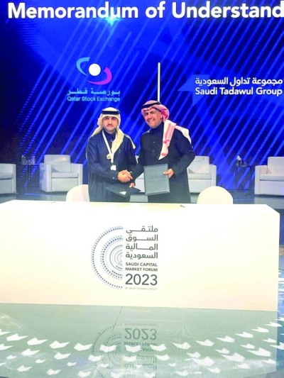 Abdul Aziz Nasser al-Emadi, acting CEO of QSE, and Khalid al-Hussan, CEO of Saudi Tadawul Group, shake hands at the MoU signing ceremony.
