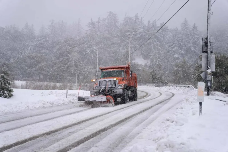 A plow clears snow on Mount Baldy Road in the town of Mount Baldy, California. (AFP)