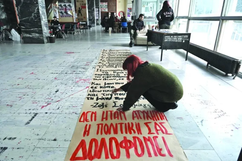 A student of Aristotle University paints a banner marked with red letters reading &#039;It was not an accident, your politics kills us&#039;, ahead of a silent demonstration in Thessaloniki, following the deadly train accident near the city of Larissa, where at least 57 people, most of them students, lost their lives.