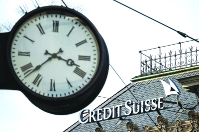 A sign of Credit Suisse is seen behind a clock at the headquarters of Switzerland’s second-biggest bank in Zurich yesterday. Switzerland’s largest bank, UBS, is in talks to buy all or part of Credit Suisse, according to a report by the Financial Times. Credit Suisse came under pressure this week as the failure of two US regional lenders rocked the sector. (AFP)