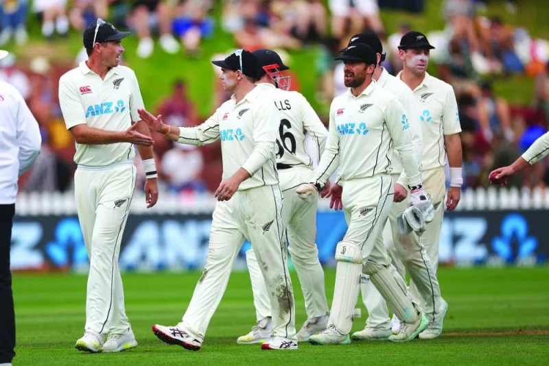New Zealand's captain Tim Southee (left) gets a high five from teammate Henry Nicholls as New Zealand walk from the field at the end of Sri Lanka's first innings during day three of the second Test at the Basin Reserve in Wellington yesterday. (AFP)