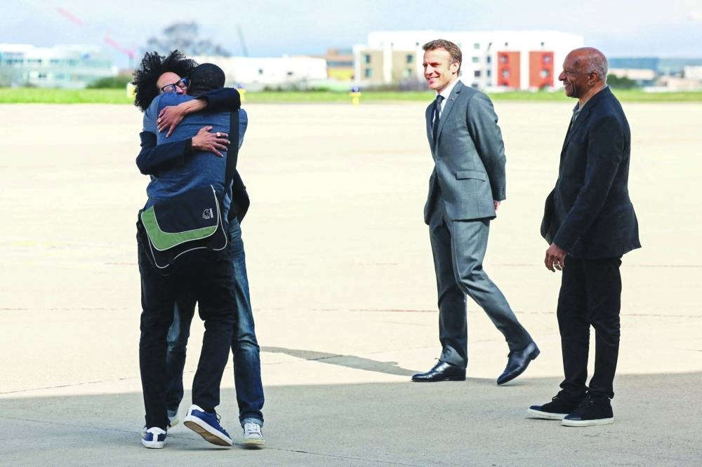 French freed hostage journalist Olivier Dubois (left), who was held hostage in Mali for nearly two years, is welcomed by family members and French President Emmanuel Macron (second right) upon his arrival at the Villacoublay airport yesterday. (AFP)