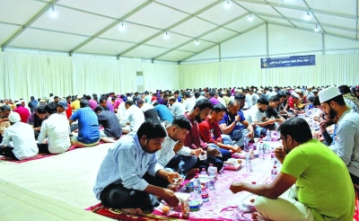 Faithful partake in a mass Iftar in a tent in Al Wakra.