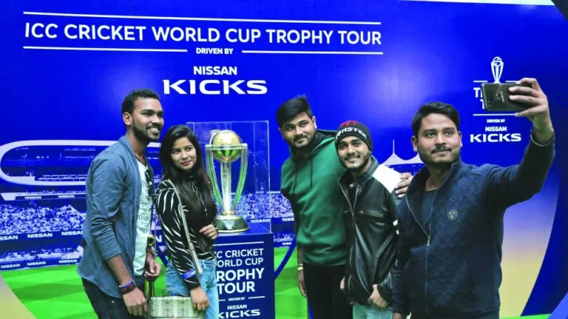 Fans take selfies next to the ICC World Cup trophy in this January 2023 file photo taken in New Delhi. India will host the ICC World Cup in Oct-Nov this year. (www.icc.com)