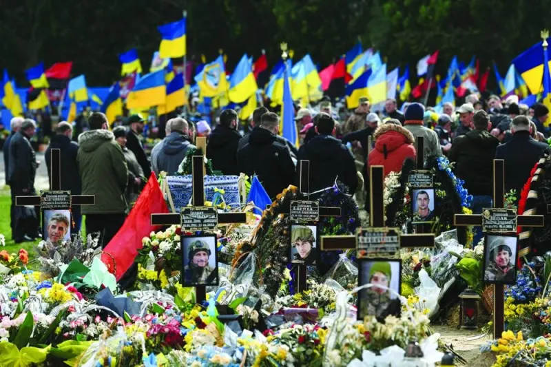 People take part in the funeral ceremony of Ukrainian servicemen killed in combat with Russian troops, at the Lychakiv cemetery in Lviv on Friday. (AFP)