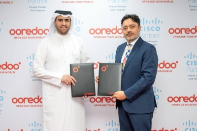 Thani al-Malki, chief business officer at Ooredoo, and Hasan Khan, general manager, Cisco Qatar, exchanging agreements.
